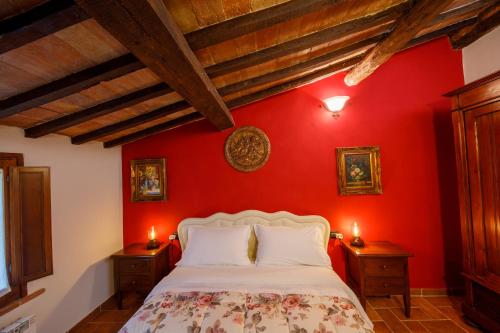 サン・マルティーノ・イン・カンポにあるBed & Breakfast Zoccoの赤い壁のベッドルーム(ベッド付)