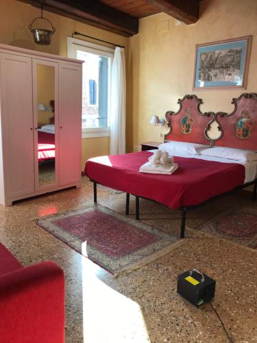 a bedroom with a large bed with a red headboard at Casa San Severo in Venice
