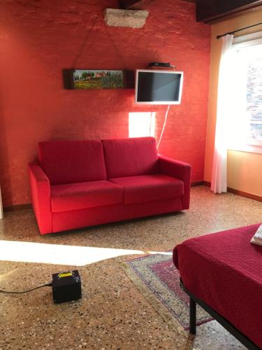 a red couch in a living room with a tv at Casa San Severo in Venice