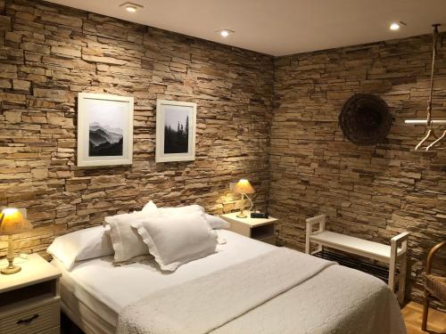 a bedroom with a large bed and a stone wall at Hostal Arostegui in Garayoa