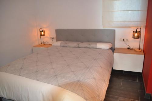 sypialnia z łóżkiem z dwoma światłami na ścianie w obiekcie Bonito apartamento con jardín w mieście Platja  d'Aro
