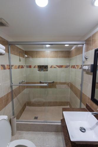 a bathroom with a shower with a toilet and a sink at Best Western Hotel Plaza Matamoros in Matamoros