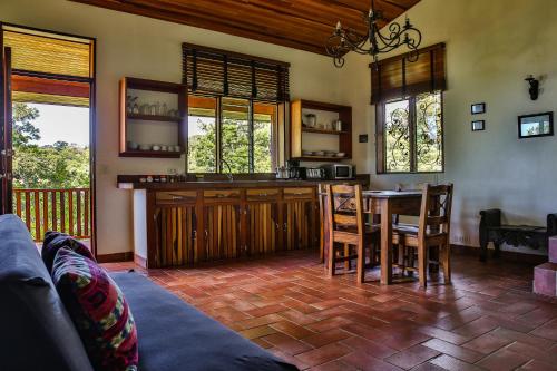 a living room with a kitchen and a table at Arco Iris Lodge in Monteverde Costa Rica