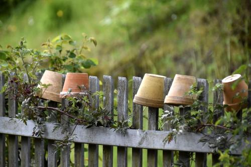 a wooden fence with flower pots on it at Urlaub im 200 Jahre alten Fachwerkhaus in Lichtenhain