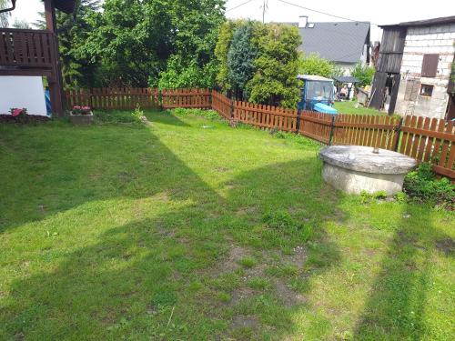 a yard with a wooden fence and a stone bench at Chalupa Šiška in Záhoří