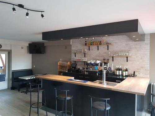 une cuisine avec un bar et des tabourets. dans l'établissement Bar du Marché - Hôtel - Restaurant, à Langeais