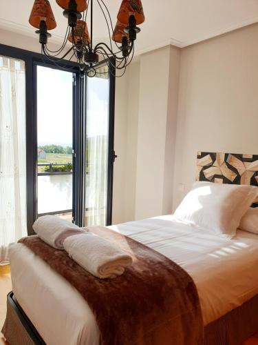 a bedroom with a large bed with a large window at Apartamento Dúplex Golf Rioja Alta in Cirueña