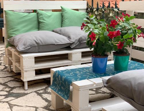 un banc avec deux oreillers et deux plantes en pot dans l'établissement Appartamento Damiana, à Venise