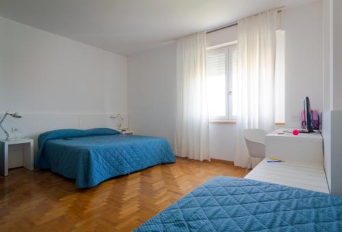 
a bedroom with a bed and a desk at Hotel Mistral in Oristano
