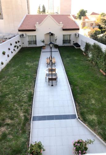 a patio with two chairs and a table on a house at Apart Hotel Granada in Neuquén