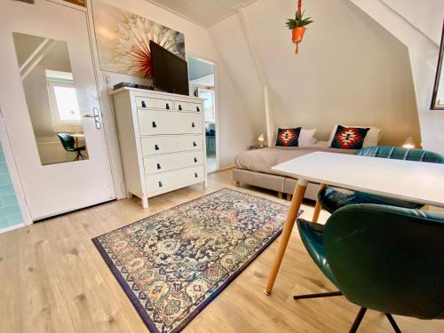 1 dormitorio con 1 cama, mesa y sillas en Odyssee, en Zandvoort