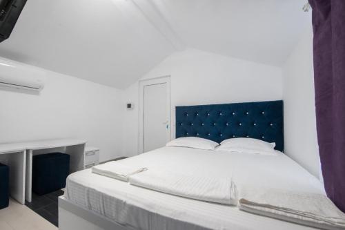 a bedroom with a large bed with a blue headboard at Vila Yanis Vama Veche in Vama Veche