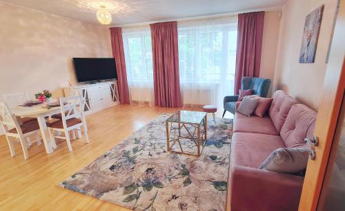 uma sala de estar com um sofá e uma mesa em Julia apartments next to AQUA PARK em Druskininkai