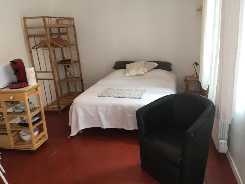 sypialnia z łóżkiem i czarnym krzesłem w obiekcie La Bernache w mieście Saint-Satur