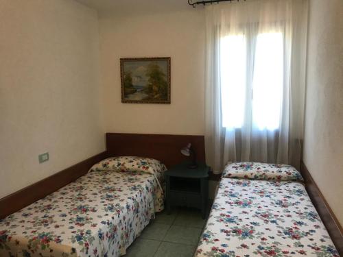 una camera d'albergo con due letti e una finestra di Casa Isidoro a Cala Liberotto