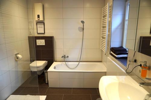 uma casa de banho com uma banheira, um WC e um lavatório. em Tier- & kinderfreundliches Ferienhaus - KEINE MONTEURE em Priesendorf