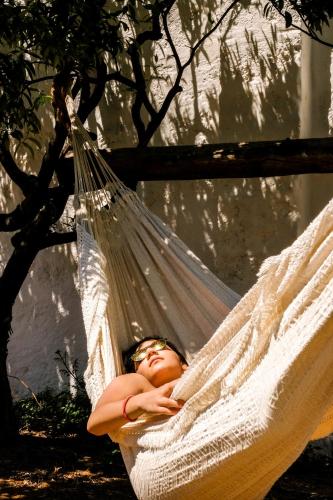 a woman sleeping in a hammock under a tree at Masseria D'Erchia in Monopoli