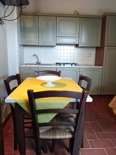 a kitchen with a yellow table and chairs at Il Casale di Luna in Saturnia