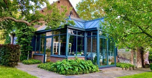 a house with blue glass windows on it at B&B De Lage Zwaluw in Lage Zwaluwe