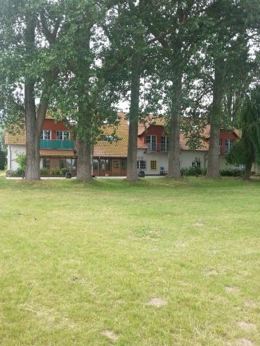 a large building with trees in a field at Haus Müritz, FeWo 17 Hecht in Zielow