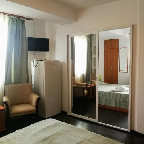 a room with a mirror and a bedroom with a bed at Vila Iulia in Eforie Nord