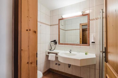 een badkamer met een wastafel, een spiegel en een toilet bij Hotel Bayrischer Löwe in Osterhofen