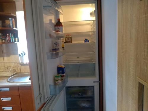 an empty refrigerator with its door open in a kitchen at Zacisze nad Rospudą in Filipów