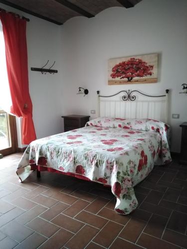 a bedroom with a bed with a floral bedspread at Il Casale di Luna in Saturnia