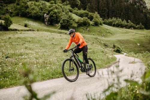 a man riding a bike down a road at Mari Pop Hotel in Ried im Zillertal