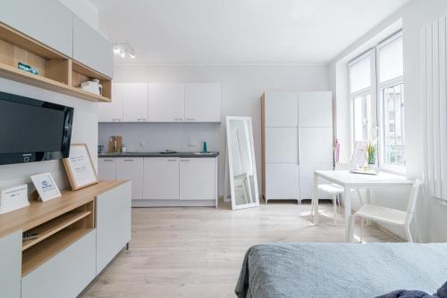 a white apartment with a kitchen and a living room at Apartment New & Nice in Gdańsk