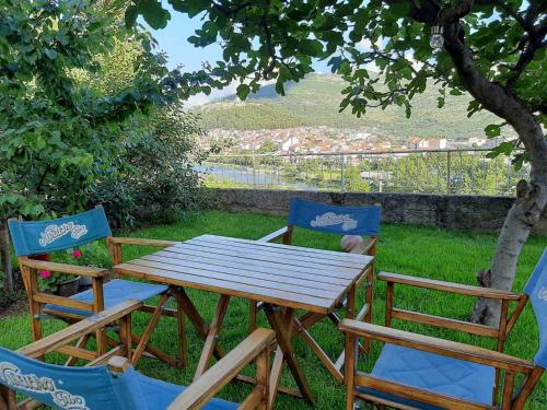 a wooden table and two chairs sitting next to a tree at Apartment Nijona in Trebinje