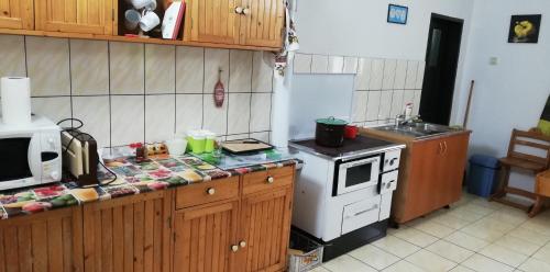 cocina con fogones blancos y microondas en Casa Robildi, en Topliţa