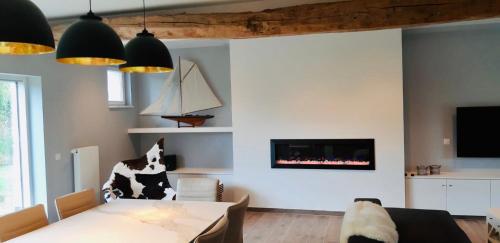 een woonkamer met een tafel en een open haard bij Demeure de charme haut de gamme - Piscine chauffée in Lissewege