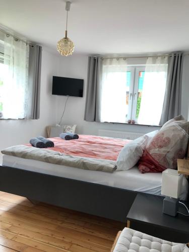 a large bed in a bedroom with two windows at Ferienwohnung Kleine Auszeit in Maring-Noviand