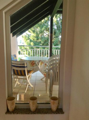 a window view of a patio with a table and chairs at Spacious Apartment 3.5 with Swimmingpool in Attalens