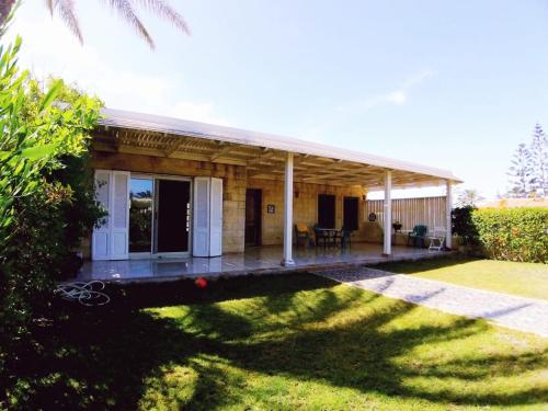 a house with a porch and a grass yard at Villa with Roof, Private Garden and Backyard in North Coast - Families Only فيلا مستقلة الساحل الشمالي - عائلات فقط in Dawwār Abū Maḩrūs