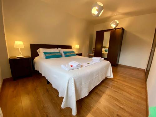 a bedroom with a large white bed with blue pillows at Hotel La Cuna del Sella in Oseja de Sajambre