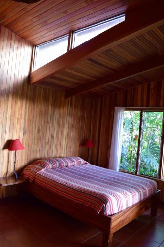 a bedroom with a bed with two lamps and a window at Arco Iris Lodge in Monteverde Costa Rica