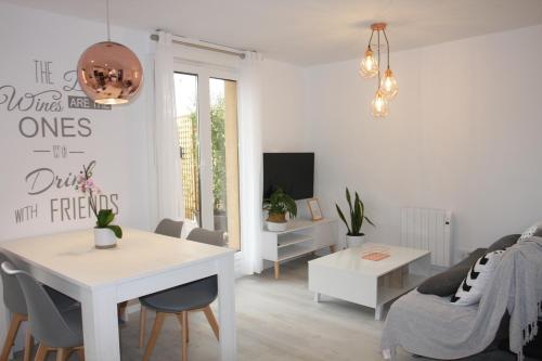 a white living room with a table and a couch at Apartamentos La Herradura Terraza in Haro