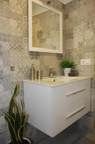 a bathroom with a white sink and a mirror at Apartamentos La Herradura Terraza in Haro