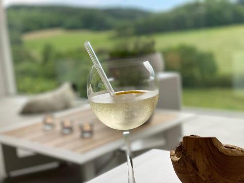 a glass of white wine sitting on top of a table at L'Auf der Tomm in Martelange