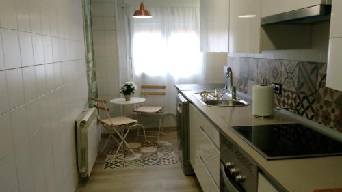 eine kleine Küche mit einem Waschbecken und einem Tisch in der Unterkunft Apartamento Madrid Retiro M-30 in Madrid