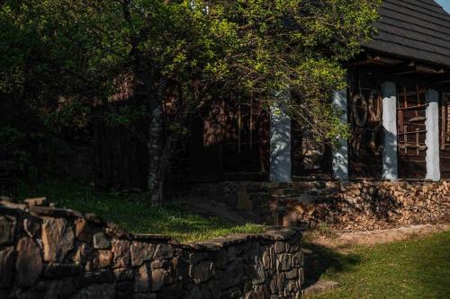 a stone wall in front of a house at Zbojnícke Chalúpky in Čavoj