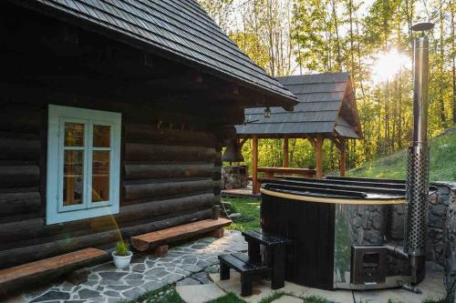 a log cabin with a fireplace and a gazebo at Zbojnícke Chalúpky in Čavoj