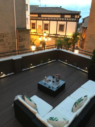 a patio with a table and chairs on a roof at Apartamentos La Herradura Terraza in Haro