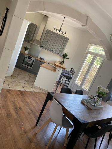 une cuisine et une salle à manger avec une table et des chaises dans l'établissement Appartement cosy et moderne, proche Cité des Papes, à Avignon