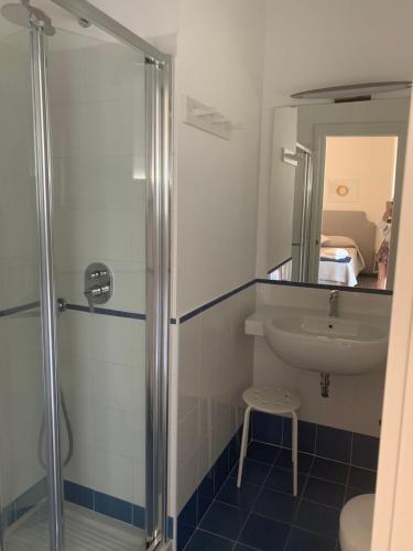 bagno con doccia, lavandino e specchio di Angelina Apartments Amalfi Coast a Maiori
