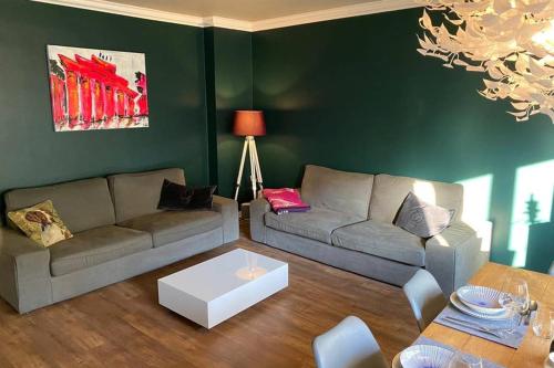 ein Wohnzimmer mit einem Sofa und einem Tisch in der Unterkunft Fördestyle, Stilvolle Wohnung in zentraler Lage in Kiel
