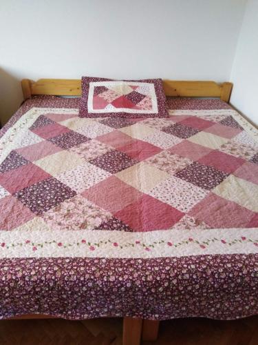 a quilt on a bed in a room at Apartman Tara in Vrdnik