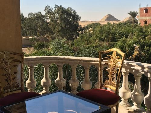 a balcony with two chairs and a view of the desert at Sakkara Inn in Cairo